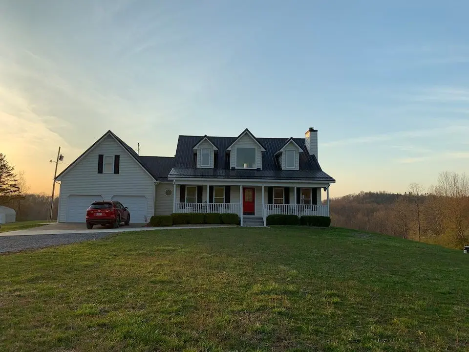 A house with a red truck parked in front of it.